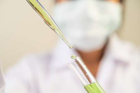 Scientists wear masks and gloves, carrying beakers with vaccines.